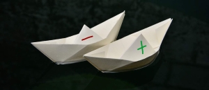 Paper boats with a plus and a minus